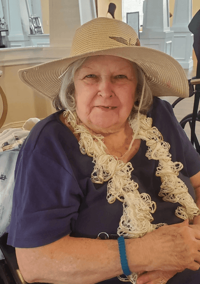 A resident wearing a large hat and smiling