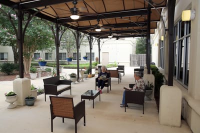 Residents enjoying a shaded outdoor seating area