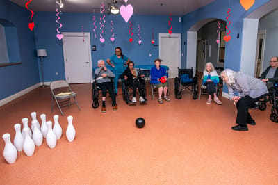 Residents participating in a bowling activity in a common area