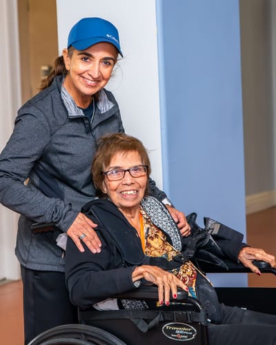 Staff member posing with a resident in wheel chair