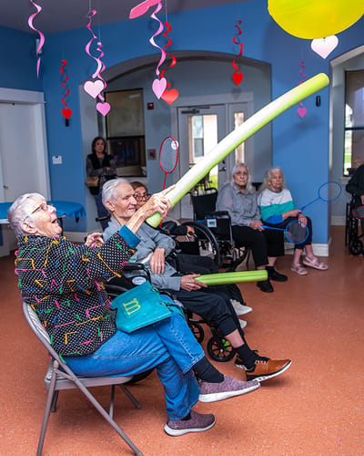 Residents engaged in an activity with colorful pool noodles