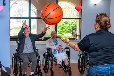 Residents participating in a basketball activity indoors