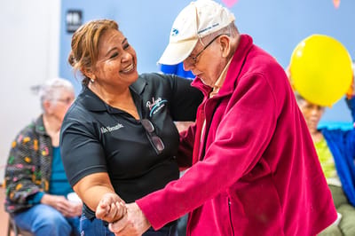 A staff member assisting a resident during an activity