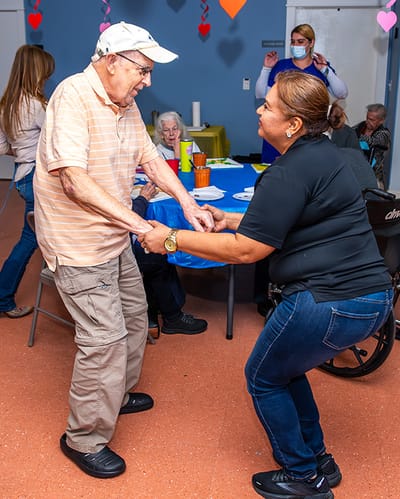 Residents dancing together in an activity room