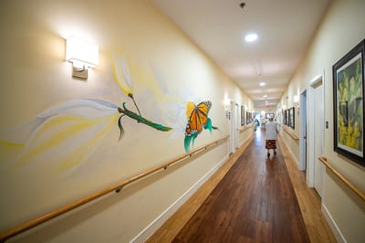 Resident walking down a beautifully decorated hallway
