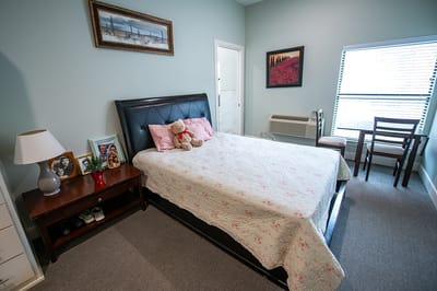A well-furnished private resident room with a bed and seating area