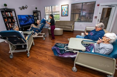 Residents engaged in a common area activity with staff assistance