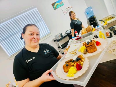 Staff member serving a delicious breakfast meal