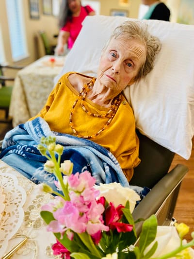 A resident in a cozy interior setting with flowers