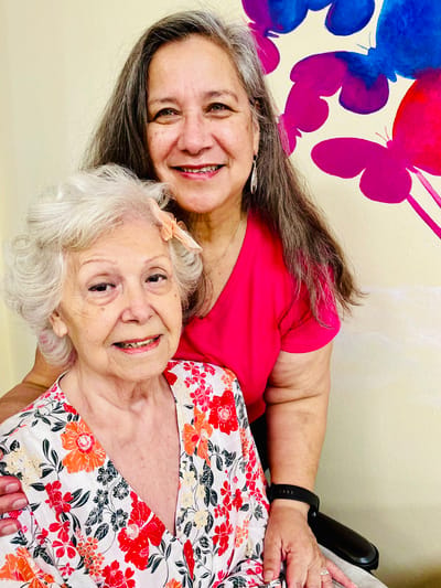 A resident and staff member smiling together