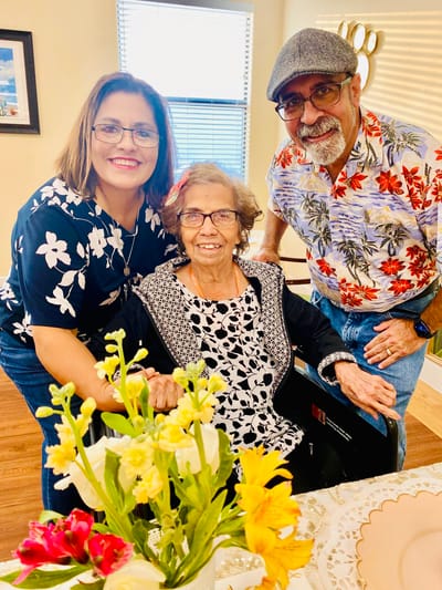 Two staff members with a resident in a bright room