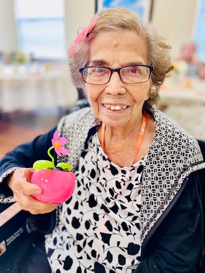 Resident smiling with a colorful flower decoration