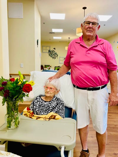 A resident sitting with a visitor in a common area