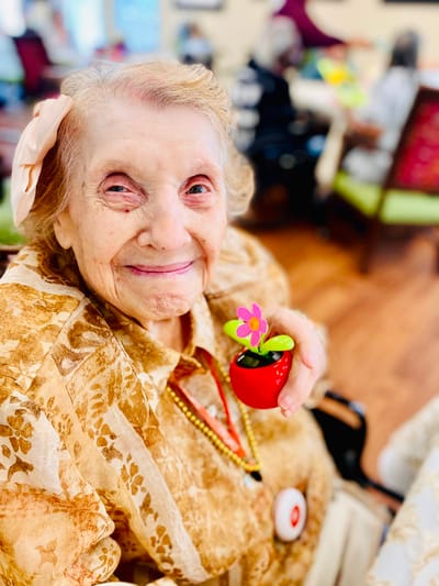 Resident smiling with a flower decoration