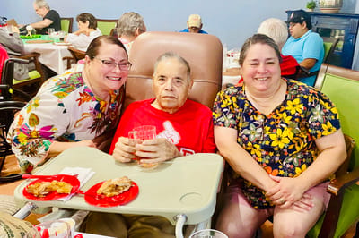 Three residents enjoying a meal together in a dining area