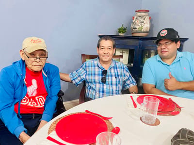 Three residents smiling around a dining table