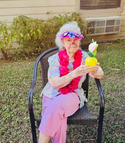Resident enjoying a drink in a garden setting