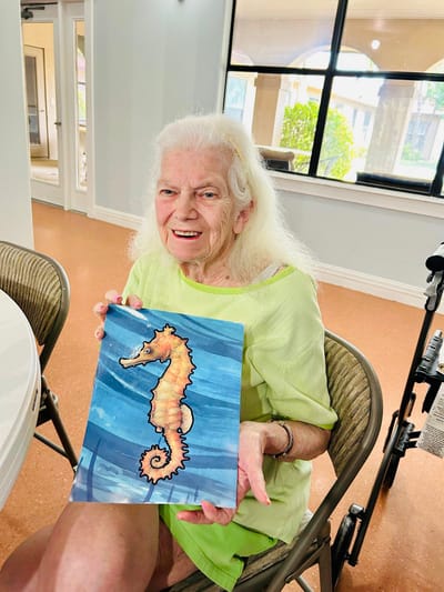 Resident displaying a seahorse artwork in common area