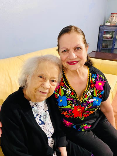 Resident and staff member posing together in a cozy setting