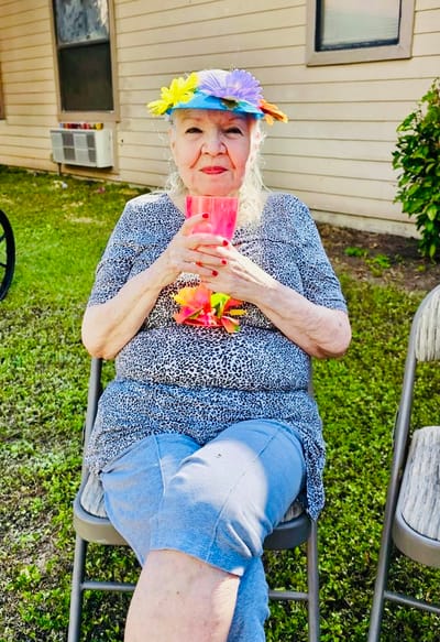 A resident enjoying a drink outdoors with a flower crown