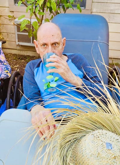 Resident enjoying a drink outdoors in a casual setting