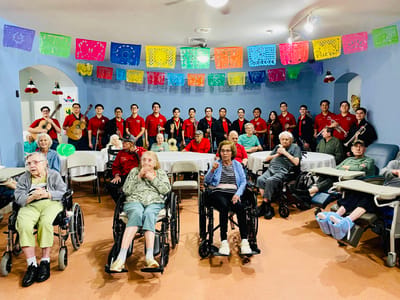 Residents and staff gathered for an event in an activity room