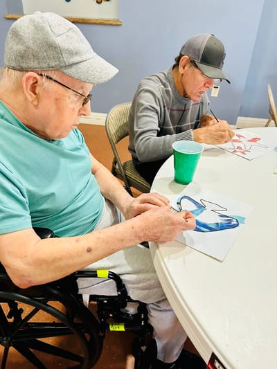 Two residents engaged in an art activity at a table