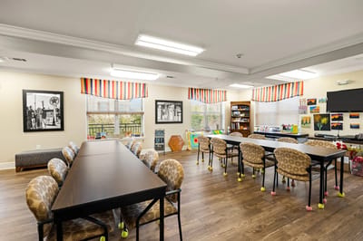 Bright and colorful activity room with tables and art