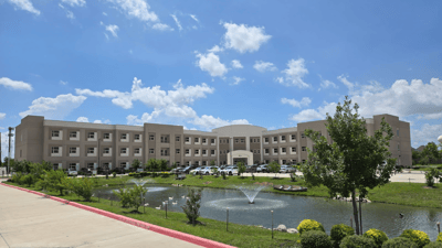 Exterior view of Everspring Assisted Living building with pond