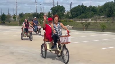 Residents riding tricycles in a parking lot