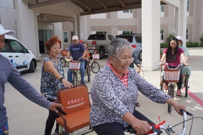 Residents engaging in a cycling activity outside the facility