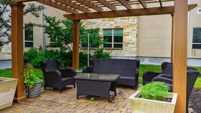 Outdoor seating area with wicker furniture and greenery