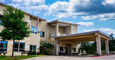 Exterior view of the facility with landscaping and flag
