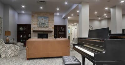Interior view of a common area with a piano and seating