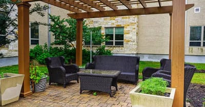 Outdoor seating area with wicker furniture beneath a pergola