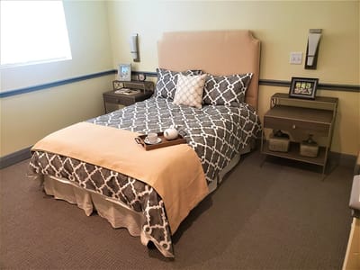 Cozy decorated resident room with bed and bedside table