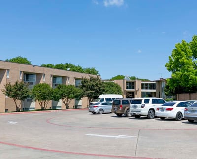 Exterior view of the facility with parking and greenery