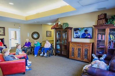 Residents socializing in a common area with a television