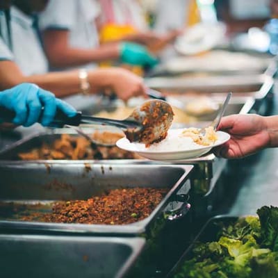 Staff serving food to residents in a dining area