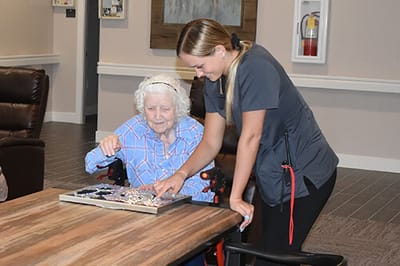 Resident and staff engaged in a puzzle activity