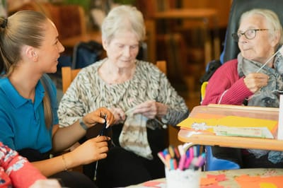 Residents engaging in a crafting activity with staff