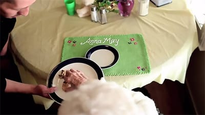 Caregiver assisting a resident with a meal