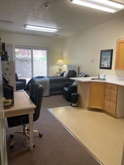 A private resident room with comfortable seating and a kitchenette