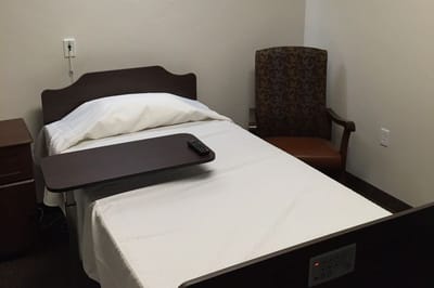 Private resident room with a bed and chair