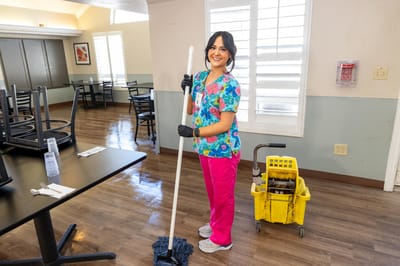 Staff member cleaning in the dining room area
