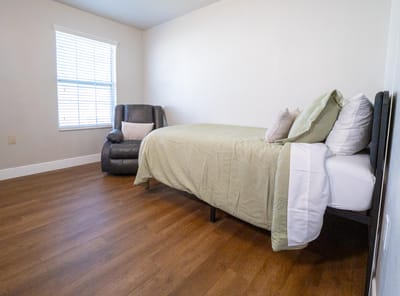 Private resident room with bed and chair