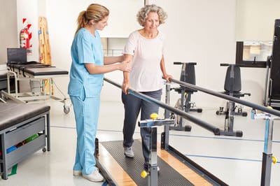 Therapist assisting resident with rehabilitation exercise