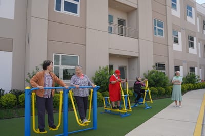 Residents engaging with outdoor exercise equipment