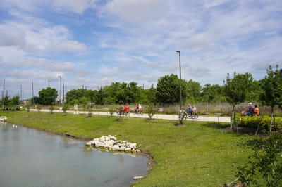 Residents biking along a scenic pathway near the facility
