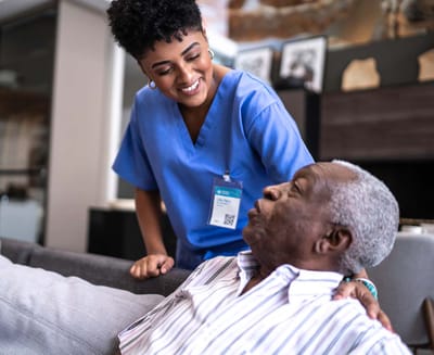 Rocky Mountain Care – Summit Ridge Assisted Living OC LLC, nursing home in Douglas, WY — Caregiver interacting with an elderly resident in a cozy